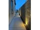 Exterior shot of the side yard, features a concrete walkway and landscape lighting at 12844 New Providence St, Las Vegas, NV 89141