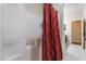 An interior view of a shower with a red and gold shower curtain and white tiled walls at 184 Cullerton St, Las Vegas, NV 89148