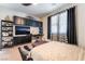 Bedroom with built-in shelving, a television, and a comfortable bed near a bright window at 184 Cullerton St, Las Vegas, NV 89148