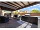 An outdoor kitchen boasts a built-in BBQ, fireplace, and cozy seating under a pergola, perfect for entertaining at 184 Cullerton St, Las Vegas, NV 89148