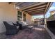 Covered patio space featuring outdoor furniture, a stone fireplace, and an open view to a beautifully landscaped yard at 184 Cullerton St, Las Vegas, NV 89148