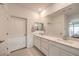 Bright bathroom features dual sinks with a stone countertop and large mirror at 2114 Thelen Ave, North Las Vegas, NV 89086
