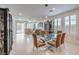 Open-concept dining area with a glass-top table, seating for six, tile floors, and views of the living room at 2114 Thelen Ave, North Las Vegas, NV 89086