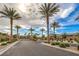 Community entrance featuring palm trees, lush landscaping, and a secure gated entry at 2114 Thelen Ave, North Las Vegas, NV 89086