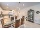 Bright kitchen and dining area with stainless appliances, granite counters, and a glass-top dining table at 2114 Thelen Ave, North Las Vegas, NV 89086