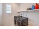 Modern laundry room with front-loading washer and dryer and window with blinds at 2114 Thelen Ave, North Las Vegas, NV 89086