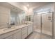 A bathroom with double sinks, light countertops, and a frameless glass shower with a seat at 2114 Thelen Ave, North Las Vegas, NV 89086