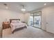 An elegant main bedroom features carpet, a ceiling fan, and a sliding glass door to the patio at 2114 Thelen Ave, North Las Vegas, NV 89086