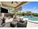 Under a covered patio, enjoy cozy outdoor seating and views of the pool at 2117 Mountain Rail Dr, North Las Vegas, NV 89084