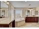 Bright bathroom features a double vanity, soaking tub and beautiful tile flooring at 2117 Mountain Rail Dr, North Las Vegas, NV 89084