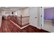 Upstairs hallway with wood floors, white walls and access to the other rooms at 2117 Mountain Rail Dr, North Las Vegas, NV 89084