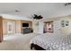 Spacious main bedroom with a large bed, carpeted floor, ceiling fan, television and plenty of storage at 2117 Mountain Rail Dr, North Las Vegas, NV 89084