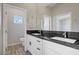 Bright bathroom with double sink vanity, black granite countertop, and modern fixtures at 2130 Revere St, North Las Vegas, NV 89030