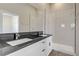 Modern bathroom featuring double sink, black granite countertop, and walk-in shower at 2130 Revere St, North Las Vegas, NV 89030