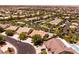 Wide aerial shot displaying a neighborhood with tree-lined streets and a few private swimming pools in backyards at 2547 Serenity Hollow Dr, Henderson, NV 89052