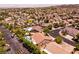Expansive aerial view of a desert community showcasing numerous houses, lush landscaping, and vibrant swimming pools at 2547 Serenity Hollow Dr, Henderson, NV 89052