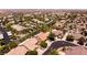 Overhead view of a desert neighborhood featuring well-maintained homes, tree-lined streets, and community parking areas at 2547 Serenity Hollow Dr, Henderson, NV 89052