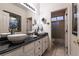 Bathroom featuring dual sinks with modern fixtures, large mirrors, and mosaic tile at 2547 Serenity Hollow Dr, Henderson, NV 89052