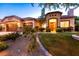 Well-maintained front yard featuring desert landscaping, green lawn, and an arched entryway at 2547 Serenity Hollow Dr, Henderson, NV 89052