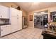 Bright kitchen with tile floors, white cabinets, and a sliding glass door leading to the patio at 2547 Serenity Hollow Dr, Henderson, NV 89052