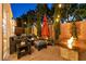 Cozy backyard patio with comfortable seating, a fire pit, and string lights for evening relaxation at 2547 Serenity Hollow Dr, Henderson, NV 89052