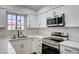 Bright kitchen showcasing stainless steel appliances, white cabinets, and a window view at 2725 S Nellis Blvd # 2036, Las Vegas, NV 89121