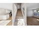 Open-concept living area with wood flooring, staircase, white walls, and natural light at 2834 Crystal Lantern Dr, Henderson, NV 89074