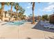 Community pool area surrounded by palm trees, lounge chairs, and well-maintained landscaping at 2834 Crystal Lantern Dr, Henderson, NV 89074