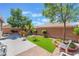 Serene backyard featuring artificial grass, a patio, and mature trees for shade and privacy at 329 Gemstone Hill Ave, North Las Vegas, NV 89031
