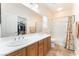 Bright bathroom with a large mirror, double sinks, and a shower-tub combination at 329 Gemstone Hill Ave, North Las Vegas, NV 89031
