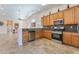 Open kitchen featuring stainless steel appliances, tile backsplash, and light wooden cabinets at 329 Gemstone Hill Ave, North Las Vegas, NV 89031