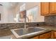 Modern kitchen sink area featuring granite countertops, tile backsplash, and window at 329 Gemstone Hill Ave, North Las Vegas, NV 89031