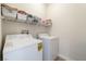 Functional laundry room equipped with a washer, dryer, and shelving for storage at 329 Gemstone Hill Ave, North Las Vegas, NV 89031