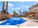 Private backyard with a refreshing pool, a charming pergola with outdoor kitchen, and serene landscaping at 4356 Sabadell St, Las Vegas, NV 89121