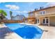 Lovely backyard featuring a large pool, a covered patio with grill, and a well-maintained lawn at 4356 Sabadell St, Las Vegas, NV 89121