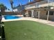 A spacious backyard features a pool, artificial turf, pergola, and a covered patio for entertainment at 4356 Sabadell St, Las Vegas, NV 89121