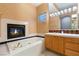 Elegant bathroom featuring a fireplace, soaking tub, custom lighting, and and sinks at 4649 Bird View Ct, Las Vegas, NV 89129