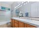 Bathroom featuring a double sink vanity with tile countertop, shower, and modern lighting at 4649 Bird View Ct, Las Vegas, NV 89129