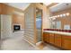 Elegant bathroom featuring a fireplace, glass block shower, custom lighting, and and sinks at 4649 Bird View Ct, Las Vegas, NV 89129