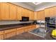 Up close shot of kitchen with dark countertops, wood cabinets, stainless steel sink and cooking range at 4649 Bird View Ct, Las Vegas, NV 89129