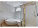 Bathroom featuring a corner bathtub with tile surround and a glass-enclosed shower with gold trim at 472 Staghorn Pass Ave, Las Vegas, NV 89183