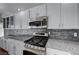 Stylish kitchen with white cabinetry, granite countertops, and stainless steel appliances at 472 Staghorn Pass Ave, Las Vegas, NV 89183