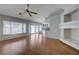 Spacious living room with wood floors, a fan, bright windows, and sliding doors leading to an outdoor space at 472 Staghorn Pass Ave, Las Vegas, NV 89183