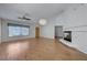 Cozy living room with hardwood floors, ceiling fan, fireplace, and large window at 472 Staghorn Pass Ave, Las Vegas, NV 89183