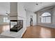 Bright living room with a fireplace, hardwood floors, vaulted ceilings, and a large arched window at 472 Staghorn Pass Ave, Las Vegas, NV 89183