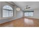 Spacious living room with wood floors, a modern light fixture and large windows allowing ample natural light at 472 Staghorn Pass Ave, Las Vegas, NV 89183