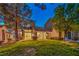 Well-maintained backyard featuring lush lawn, mature trees, and a home exterior with abundant natural light at 5010 Crooked Stick Way, Las Vegas, NV 89113