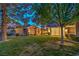 Spacious backyard features a well-manicured lawn and mature trees, highlighting the home's serene outdoor space at 5010 Crooked Stick Way, Las Vegas, NV 89113