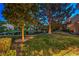Expansive backyard with lush greenery, mature trees, and tranquil pond views creating a peaceful oasis at 5010 Crooked Stick Way, Las Vegas, NV 89113