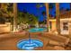 Luxurious pool and hot tub area featuring palm trees, lounge chairs, and a serene outdoor setting at 5010 Crooked Stick Way, Las Vegas, NV 89113
